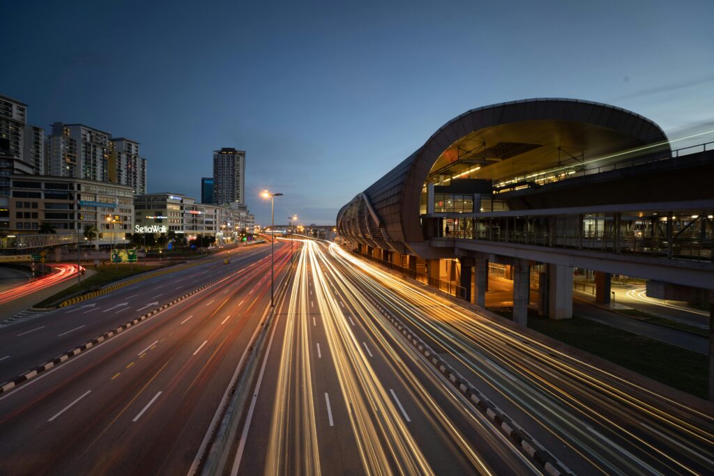 Dynamic urban scene in Puchong at night showcasing moving light trails and a modern cityscape.